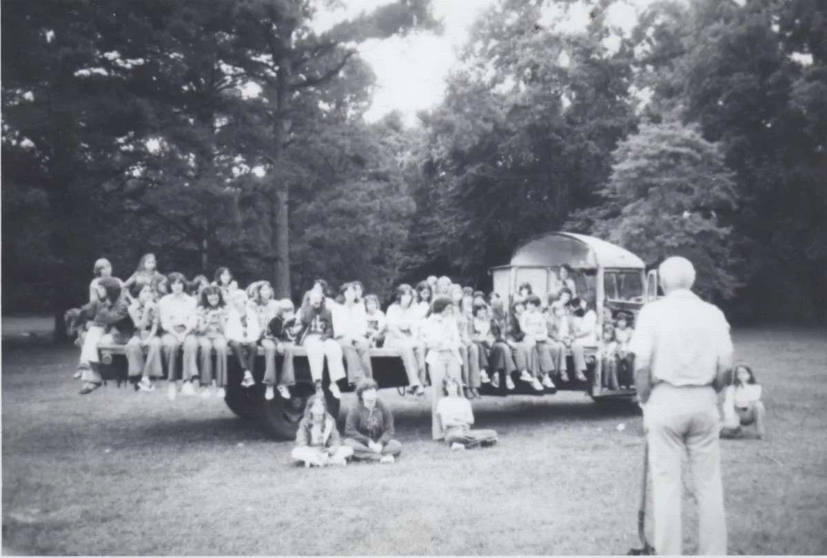 Daddy Earl Adams telling stories to campers gathered on the flatbed trailer in the 1970s